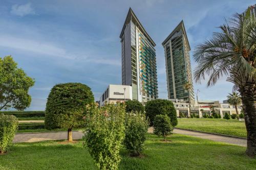 ein Park vor zwei hohen Gebäuden in der Unterkunft Hilton Batumi in Batumi
