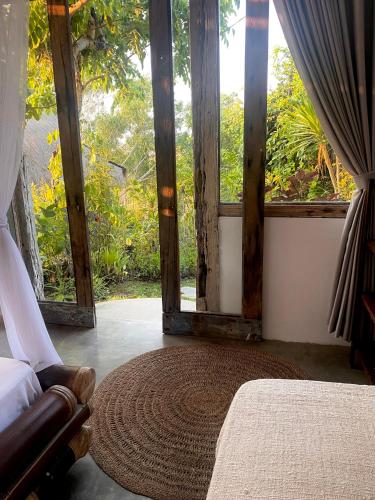 a bedroom with a bed and a large window at Vertical House Bali in Uluwatu