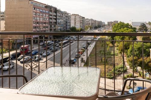 balcón con mesa y sillas en una calle de la ciudad en ID apartments B, en Tesalónica