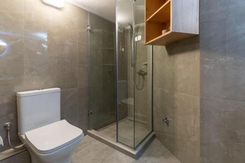 ein Bad mit einem WC und einer Glasdusche in der Unterkunft ID apartments B in Thessaloniki