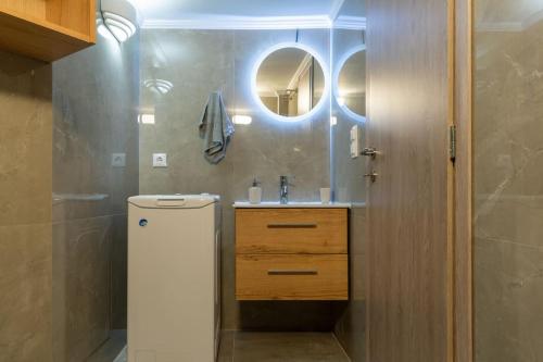 ein Bad mit einem Waschbecken und einem Spiegel in der Unterkunft ID apartments B in Thessaloniki