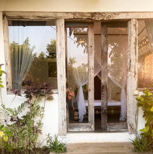 a window of a house with curtains in it at Vertical House Bali in Uluwatu