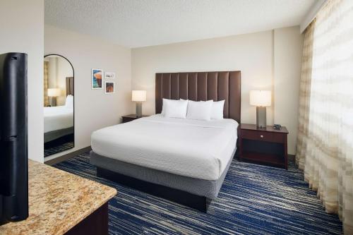 a hotel room with a bed and a television at Embassy Suites by Hilton West Palm Beach Central in West Palm Beach