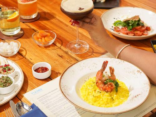 a table with a plate of food with a shrimp on top of eggs at Conrad Bengaluru in Bengaluru