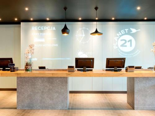a reception desk in a lobby with a clock on the wall at ibis Warszawa Centrum in Warsaw