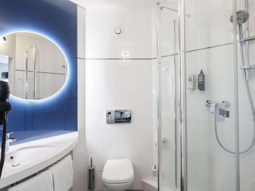 a bathroom with a shower and a toilet and a sink at ibis Warszawa Centrum in Warsaw