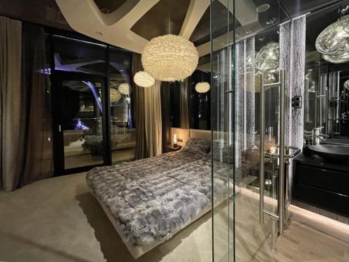 Schlafzimmer mit einem Bett und einer Glaswand in der Unterkunft Poets Garden Villa in Budapest