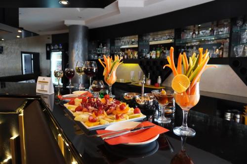 a table with a plate of food and glasses of wine at Anadolu Hotels Esenboga Thermal in Esenboga