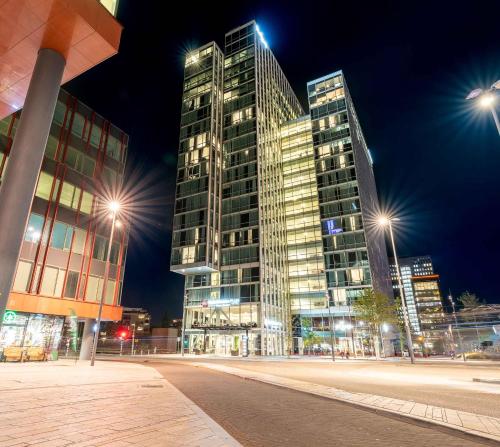 wysoki budynek w nocy z światłami ulicznymi w obiekcie Best Western Plus Plaza Almere w Almere