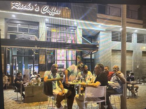 a group of people sitting at tables in front of a restaurant at appartement à oujda in Oujda