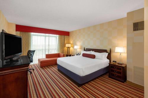 um quarto de hotel com uma cama e uma televisão de ecrã plano em Wyndham Grand Oklahoma City Downtown em Oklahoma City