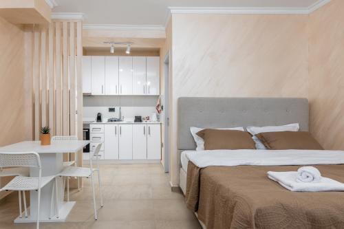 Cet appartement comprend une chambre avec deux lits, une table et une cuisine. dans l'établissement JOY APARTMENTS Zemun,Beograd, à Zemun