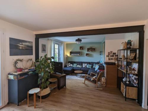 sala de estar con sofá y mesa en Maison proche base nautique JO 2024 et Disneyland Paris, en Vaires-sur-Marne