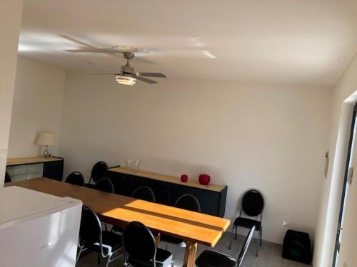 a room with a table and chairs and a ceiling fan at Gli ulivi Gualdo Tadino Uniquement de samedi à samedi Lits pour 10 personnes in Pieve di Compresseto