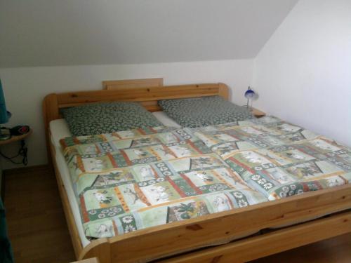 uma cama num quarto com uma cama de madeira em Ferienhaus Seepferdchen Neßmersiel em Neßmersiel