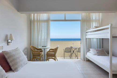 a bedroom with a bunk bed and a view of the beach at Atlantica Princess Hotel in Ixia