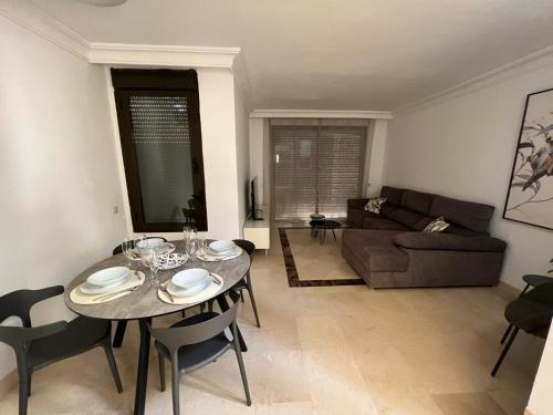 sala de estar con mesa y sofá en Moderno y acogedor adosado en Roda Golf Resort, en Roda