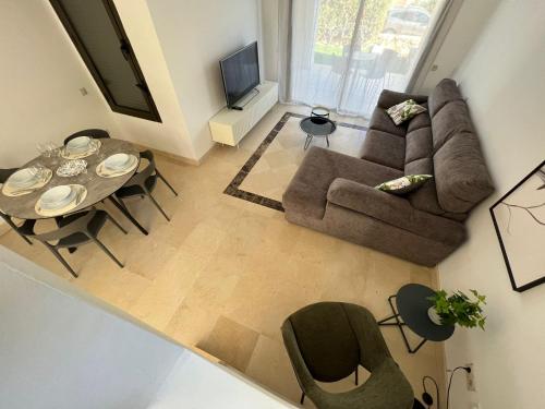 sala de estar con sofá, mesa y sillas en Moderno y acogedor adosado en Roda Golf Resort, en Roda