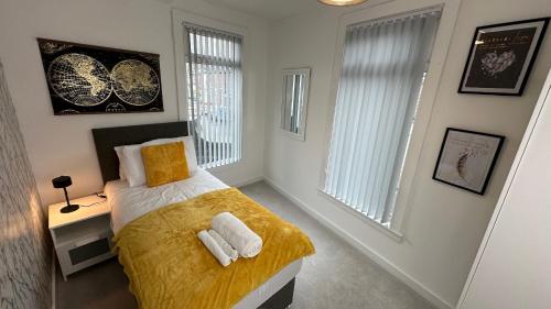 a bedroom with a bed with two towels on it at Snug apartment in the heart of Castleford in Castleford