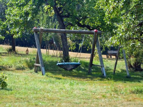 a swing set in a park with a tree at Ferienhaus am Ried in Burgweiler