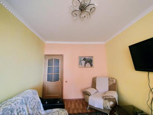 ein Wohnzimmer mit 2 Stühlen und einem Flachbild-TV in der Unterkunft Caspian breeze in Aqtau
