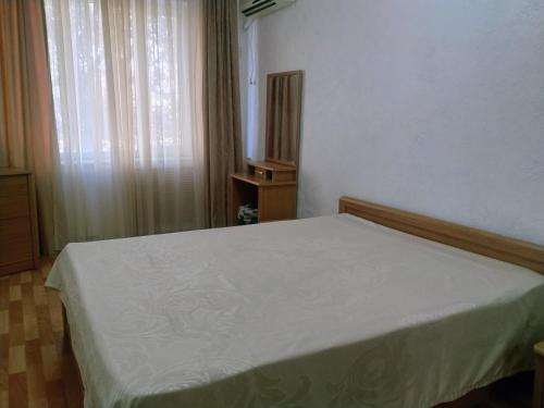 Schlafzimmer mit einem weißen Bett und einem Fenster in der Unterkunft Caspian breeze in Aqtau