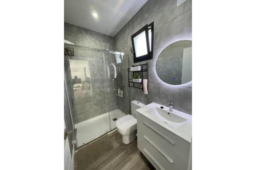 マラガにあるVilla Marietoの洗面台、トイレ、鏡のあるバスルーム