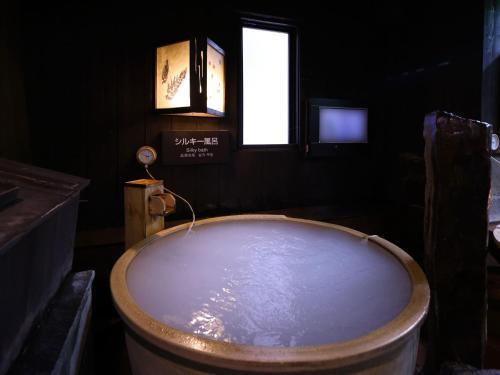 a bath tub in a room with a window at Dormy Inn Tokyo Hatchobori - Natural Hot Spring in Tokyo