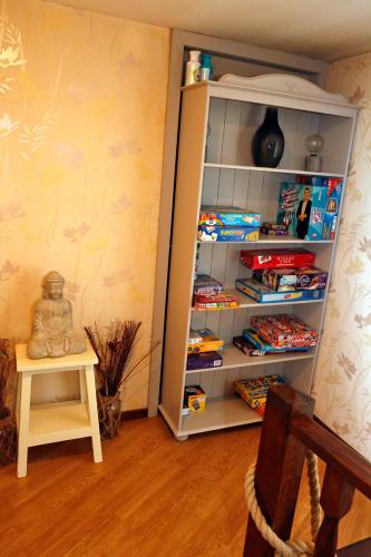 a room with a book shelf filled with toys at B&B Au Coq en Pate in Jalhay