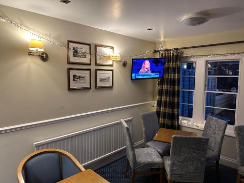 uma sala de espera com uma televisão na parede em New Birchfield Hotel em Weston-super-Mare