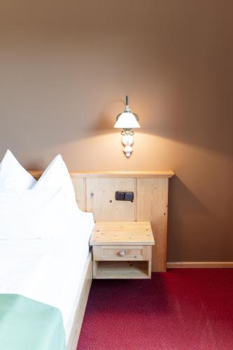 a bedroom with a bed and a nightstand with a lamp at Mahorko Wein Wellness Wasserbüffel in Glanz an der Weinstraße 