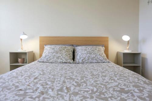 una camera da letto con un grande letto con due comodini di Appartement sans vis-à-vis proche du centre-ville a Douai