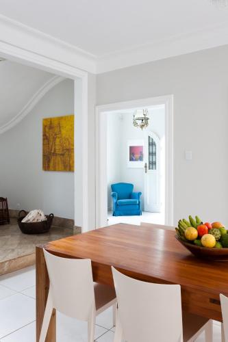 a dining room with a wooden table and white chairs at Pousada Casa da Vitória in Salvador