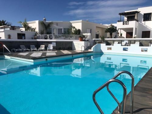 una piscina con acqua blu davanti a una casa di Casa Tranquila a Playa Honda