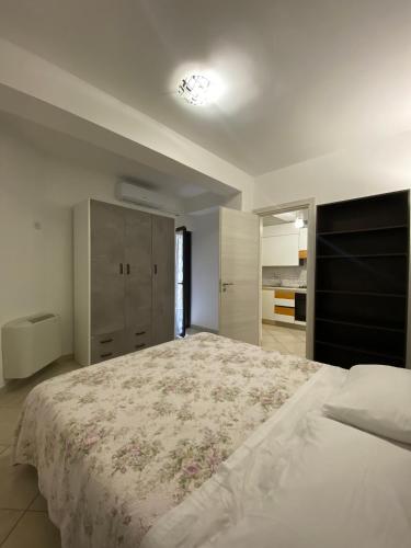 B & B IL VICOLETTO في بونتيكورفو: غرفة نوم بسرير ابيض كبير مع غطاء سرير من الزهور