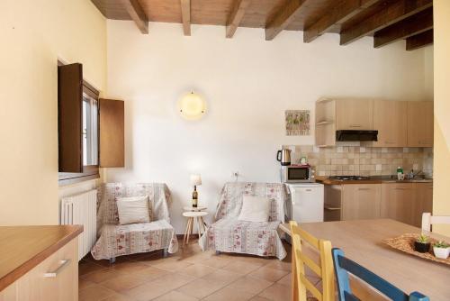 y cocina con 2 sillas y mesa. en Agriturismo - Tenuta MonteOliveto - Cottage Relax, en Vesime