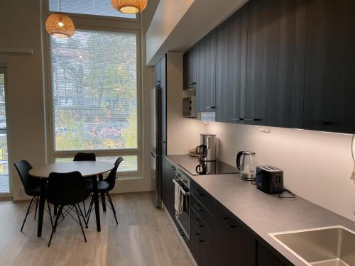 cocina con mesa, sillas y encimera en High-ceilinged apartment with balcony en Tampere