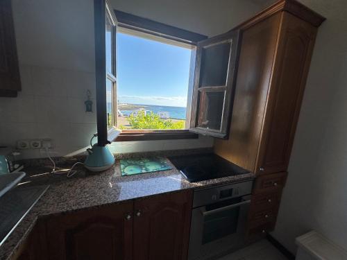 una cucina con finestra affacciata sull'oceano di Casa Tranquila a Playa Honda