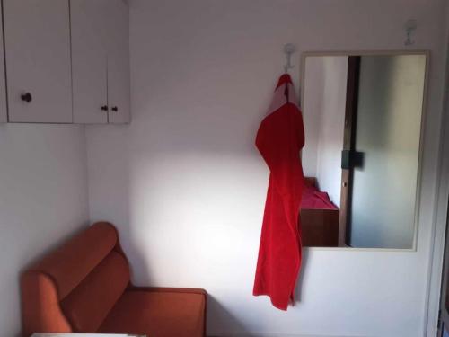 una bata roja colgada en una pared junto a un espejo en На пъпа на Варна!, en Varna