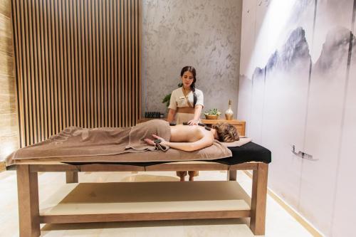 a woman laying on a massage bed in a room at Anadolu Hotels Esenboga Thermal in Esenboga