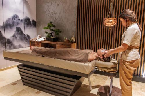 a woman in a hospital room with a patient in a bed at Anadolu Hotels Esenboga Thermal in Esenboga