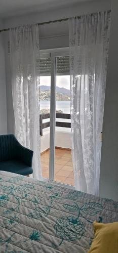 a bedroom with a bed and a view of the ocean at MARINA BEACH FRONT in La Herradura