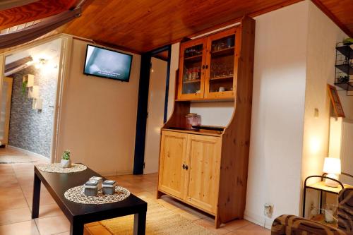 a living room with a table and a tv in a room at B&B Au Coq en Pate in Jalhay