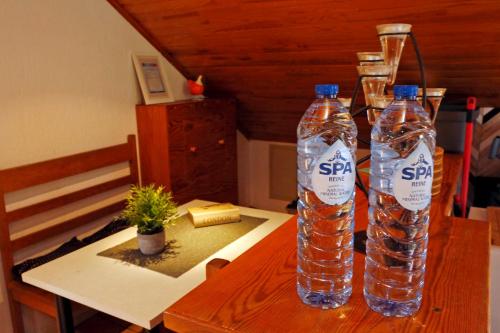 two bottles of water sitting on top of a table at B&B Au Coq en Pate in Jalhay