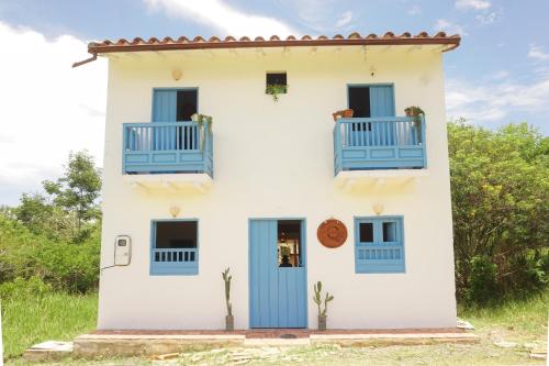 Casa blanca con puertas y ventanas azules en Casa Quintanilla Barichara en Barichara