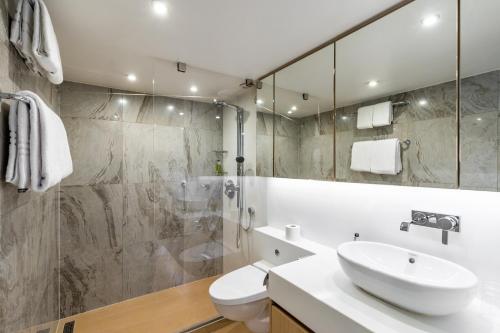 a bathroom with a sink and a toilet and a shower at KD Hotelschiff Messe und Stadion in Düsseldorf