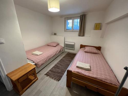 Cette chambre comprend 2 lits et une fenêtre. dans l'établissement Paris in 10 min, Cosy apartment with a courtyard, à Puteaux