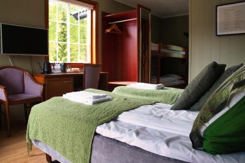 a bedroom with a green blanket on a bed at Sølvgarden Motell in Rysstad