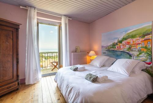une chambre avec un grand lit et une grande fenêtre dans l'établissement La Martichouette Chambres dans Maison vue sur Lac, à Marin