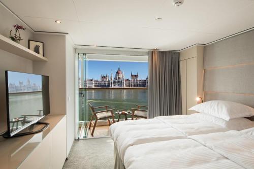 ein Hotelzimmer mit einem Bett und einem großen Fenster in der Unterkunft KD Hotelschiff Messe und Stadion in Düsseldorf